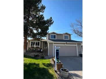 Charming two-story home featuring a well-manicured lawn and a two-car garage with a beautiful shade tree at 8975 S Coyote St, Highlands Ranch, CO 80126