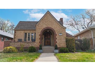 Charming brick home with arched entry, lovely landscaping, and a classic, inviting facade at 1582 Fairfax St, Denver, CO 80220