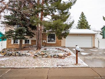 Charming two-story brick home featuring a two-car garage and well-manicured front yard at 17973 E Iowa Dr, Aurora, CO 80017