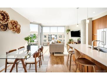 Bright living room featuring hardwood floors, large windows, and an open-concept design at 4200 W 17Th Ave # 611, Denver, CO 80204