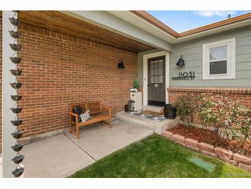 Inviting front porch with brick facade, bench, and address display creates curb appeal at 11031 Marshall St, Westminster, CO 80020