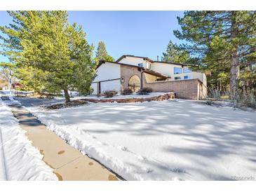 Beautiful home with snow-covered front yard and mature trees at 118 S Eldridge Way, Golden, CO 80401