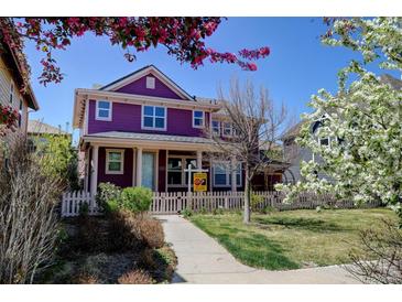 Charming two-story purple home with a picket fence and well-manicured lawn in a suburban neighborhood at 8335 E 22Nd Ave, Denver, CO 80238