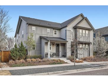 Charming gray two-story home with covered porch and manicured front yard at 8157 E 53Rd Dr, Denver, CO 80238