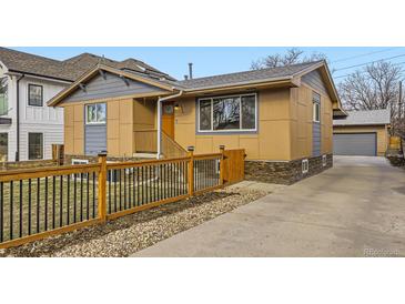 Inviting exterior of home features a modern fence, stone accents, and well-manicured landscaping at 3440 Chase St, Wheat Ridge, CO 80212