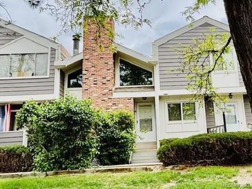 Charming townhome featuring a brick chimney, tidy landscaping, and neutral siding at 6895 W 84Th Way # 4, Arvada, CO 80003