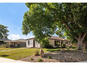 Charming one-story home with a well-manicured lawn and a mix of rock and grass landscaping at 5090 W 36Th Ave, Denver, CO 80212