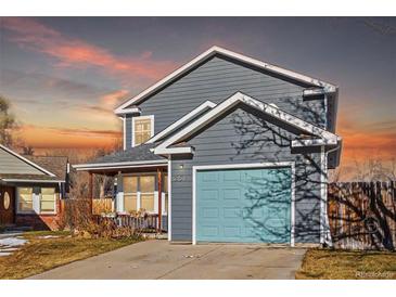 Gray two-story house with teal garage door and landscaped yard at 257 Wadsworth Cir, Longmont, CO 80504