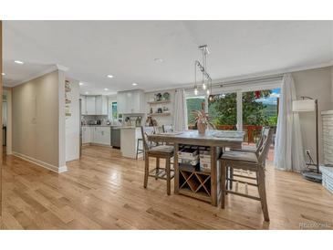 Bright, open living space with hardwood floors, modern kitchen, and dining area with scenic mountain views at 25694 Stansbery St, Conifer, CO 80433
