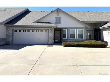 Charming single-story home with a two-car garage, stone accents, a well-maintained lawn and a paved driveway at 7777 S Biloxi Way, Aurora, CO 80016