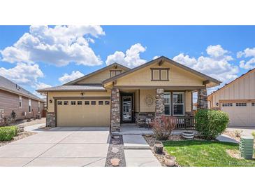 Charming single Gathering home with a stone pillar entryway, well manicured lawn, and a two-car garage at 6674 Fonder Villa Dr, Parker, CO 80134