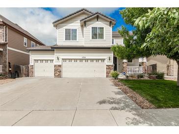 Charming two-story home with a three-car garage, stone accents, and manicured lawn at 11725 Helena St, Commerce City, CO 80022