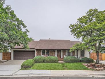 Charming single-story home with brick accents, manicured lawn, mature trees, and attached two-car garage at 3265 W 11Th Avenue Ct, Broomfield, CO 80020