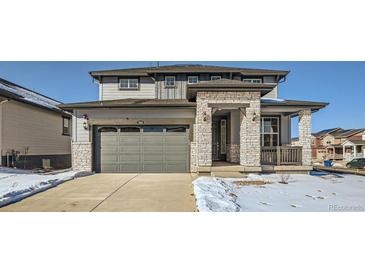 Two-story house with gray siding, stone accents, and a two-car garage at 544 Twilight St, Erie, CO 80516