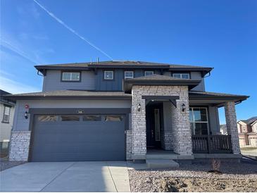 Two-story house with gray siding, stone accents, and a two-car garage at 544 Twilight St, Erie, CO 80516