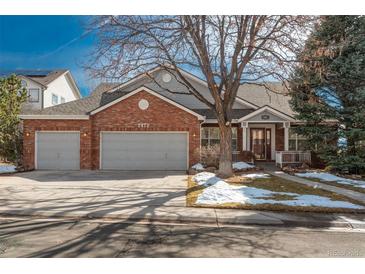 Charming brick home with a three-car garage, a well-manicured lawn, and mature trees, offering curb appeal and practicality at 2472 W Peakview Ct, Littleton, CO 80120