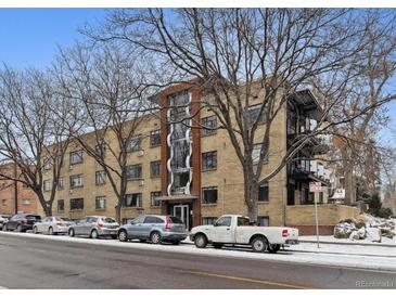 Apartment building exterior with brick facade, multiple windows, and street parking at 500 E 11Th Ave # 401, Denver, CO 80203