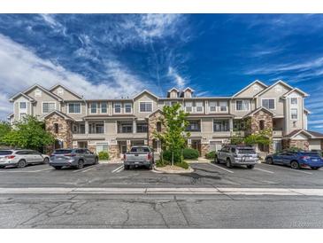 Attractive condominium building with stone accents, balconies, and ample parking on a sunny day at 12711 Colorado Blvd # 714G, Thornton, CO 80241