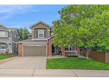Charming two-story home with a well-manicured lawn, mature trees and a brick and siding facade at 3860 Mallard Dr, Highlands Ranch, CO 80126