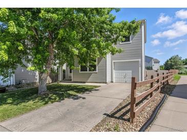 Two-story home with gray siding, front lawn with a large tree, and a driveway leading to an attached garage at 11898 W Tufts Pl, Morrison, CO 80465