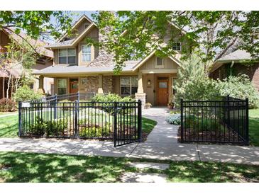Charming home exterior featuring a landscaped front yard with a black metal fence at 2042 S Clayton St, Denver, CO 80210