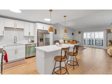 Modern kitchen with white cabinets, stainless steel appliances, and an island at 660 S Alton Way # 10D, Denver, CO 80247