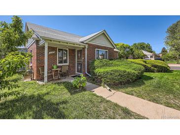 Charming brick home with a covered porch and well-maintained landscaping on a sunny day at 2361 Olive St, Denver, CO 80207