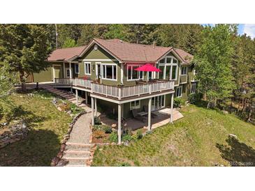 Beautiful two-story home with an inviting deck and lush landscaping at 20410 Brookmont Rd, Morrison, CO 80465