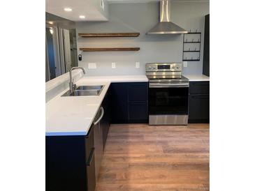 Modern kitchen features stainless steel appliances, wood shelves, and dark cabinets with light countertops at 1040 Stuart St, Denver, CO 80204