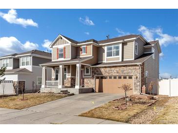 Charming two-story home featuring stone accents, a covered porch, and a well-maintained front yard at 12217 Skywalk St, Parker, CO 80134