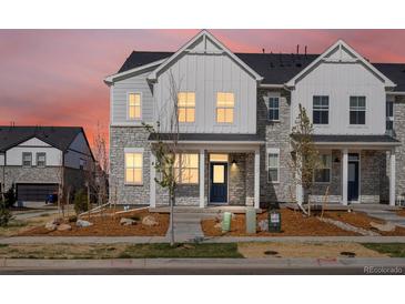 Charming townhome features a stone and white siding exterior with a covered front porch and landscaped front yard at 755 N Tibet St, Aurora, CO 80018