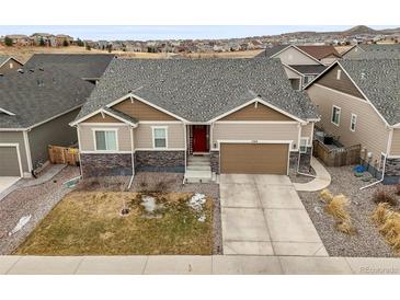 Charming single-Gathering home features a well-maintained lawn, a two-car garage, and a red front door at 7268 Greenwater Cir, Castle Rock, CO 80108