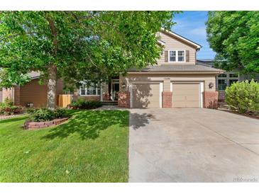 Charming two-story home with a well-maintained lawn, mature tree and a two car garage at 13486 Clayton St, Thornton, CO 80241