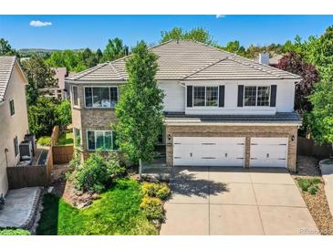 Beautiful two-story home with a three-car garage, tile roof, and a combination of brick and white siding at 2950 Wyecliff Ln, Highlands Ranch, CO 80126