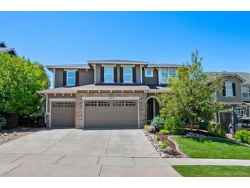Charming two-story home featuring stone accents, three-car garage, landscaped yard, and welcoming curb appeal at 12015 Blackwell Way, Parker, CO 80138