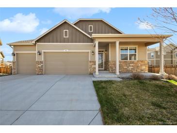 Charming, single-Gathering home with a two-car garage, stone accents, and manicured lawn at 806 Peony Ct, Brighton, CO 80601