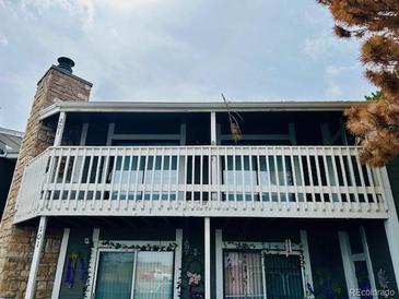 Exterior view of a condo building with a brick facade and a balcony with a white railing at 18193 E Kentucky Ave # 201, Aurora, CO 80017