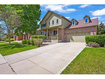 Charming two-story home featuring a brick facade, covered porch, manicured lawn and attached two car garage at 13445 Kearney St, Thornton, CO 80602