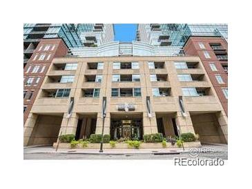 Multi-story building with brick facade, covered parking, and manicured landscaping on a sunny day at 1700 Bassett St # 1301, Denver, CO 80202