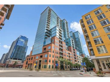 Contemporary condo building featuring a brick facade and glass windows against a blue sky backdrop at 1700 Bassett St # 1301, Denver, CO 80202