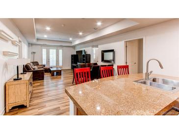 A kitchen island overlooks the living and dining areas of this open-concept home design at 2200 S University Blvd # 212, Denver, CO 80210