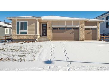 Ranch style home with two-car garage and snow-covered front yard at 3826 N Elk St, Aurora, CO 80019