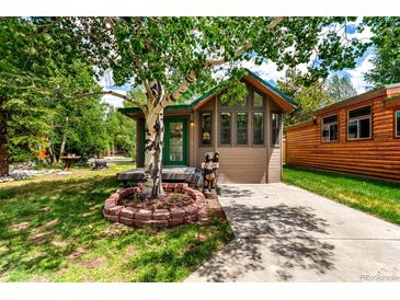 Charming exterior of this cozy home, featuring inviting curb appeal and a beautiful mature birch tree in the front yard at 85 Revett Dr # 15, Breckenridge, CO 80424