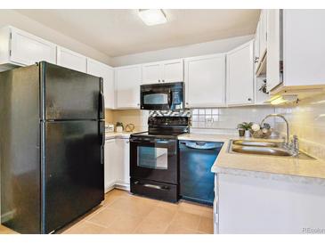 Well-lit kitchen featuring a black appliance set and white cabinetry, with tile backsplash and countertops at 585 S Alton Way # 6B, Denver, CO 80247