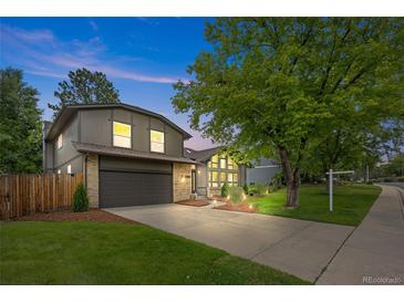 Charming gray two-story home featuring a well-manicured lawn, mature trees, and inviting curb appeal at 11035 E Berry Ave, Englewood, CO 80111