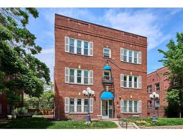 Charming brick apartment building featuring awnings and manicured landscaping at 1351 N Washington St # 23, Denver, CO 80203