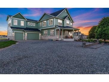 Charming two-story home with three-car garage, landscaped yard and a welcoming front porch at 881 Kirby Ct, Watkins, CO 80137