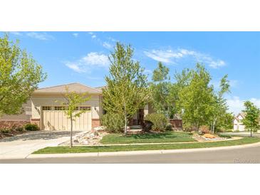 Charming front exterior with a manicured lawn, mature trees, and a beige two-car garage at 4519 Silver Mountain Loop, Broomfield, CO 80023