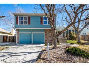 Charming two-story home featuring blue siding, red shutters, and a two-car garage at 10058 Lewis St, Broomfield, CO 80021