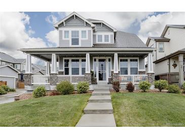 Charming two-story home with a welcoming front porch and well-manicured lawn at 640 E Fremont Pl, Littleton, CO 80122